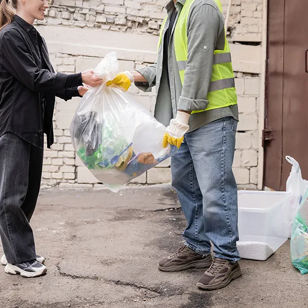 cropped-view-of-smiling-volunteer-giving-plastic-b-2024-11-07-20-51-03-utc-68a2dcdc17759